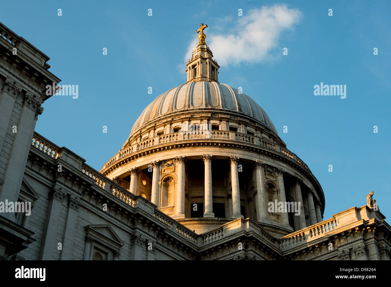 St Paul's Cathedral Dome London England // LONDON, England — The dome of St Paul's Cathedral is illuminated by late afternoon golden light, highlighting one of London's most distinctive architectural landmarks. The current cathedral, designed by Sir Christopher Wren following the Great Fire of London, was constructed between 1675 and 1710, featuring its iconic 365-foot dome that dominated the London skyline for centuries. A place of worship has existed on this site since 604 AD, with the present structure representing the fifth cathedral to occupy the location. St Paul's has served as the sett Stock Photo