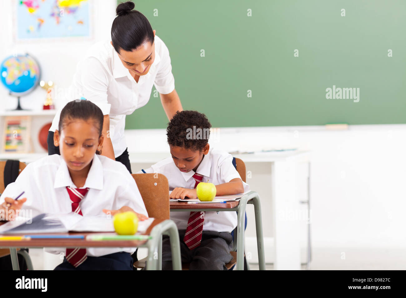 caring elementary school teacher and students in classroom Stock Photo
