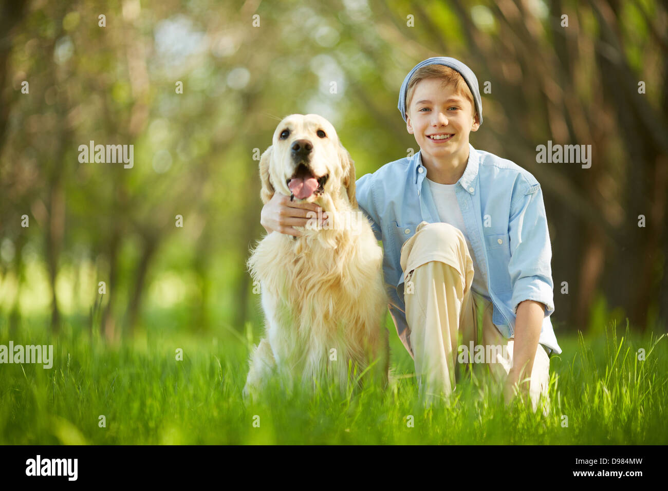 Portrait of cute lad embracing his white labrador Stock Photo