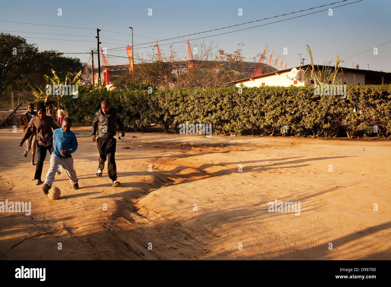 Young African children play football outside home only few metres away Mbombela stadium in Nelspruit in Mpumalanga South Africa Stock Photo
