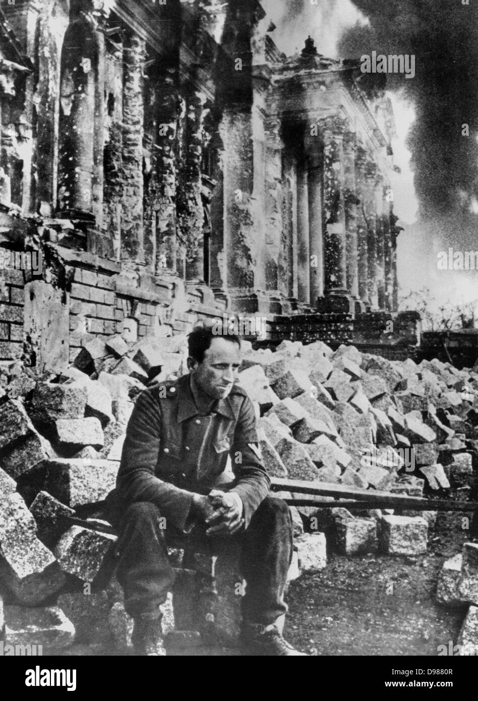 Second World War: German soldier sits amongst the ruins of the Reichstag in Berlin after the Russian army entered the city in Stock Photo
