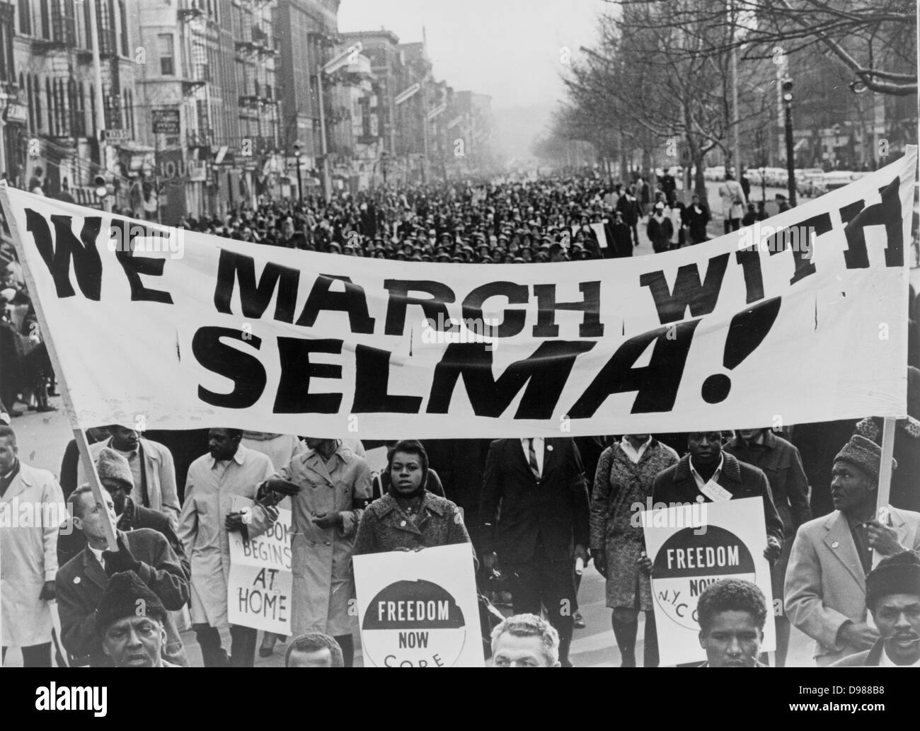 Marchers carrying banner lead the way as 15,000 parade. Photograph shows marchers carrying banner 'We march with Selma!' on street in Harlem, New York City, New York. 1965 March. ' World Telegram & Sun' photograph by Stanley Wolfson. Stock Photo