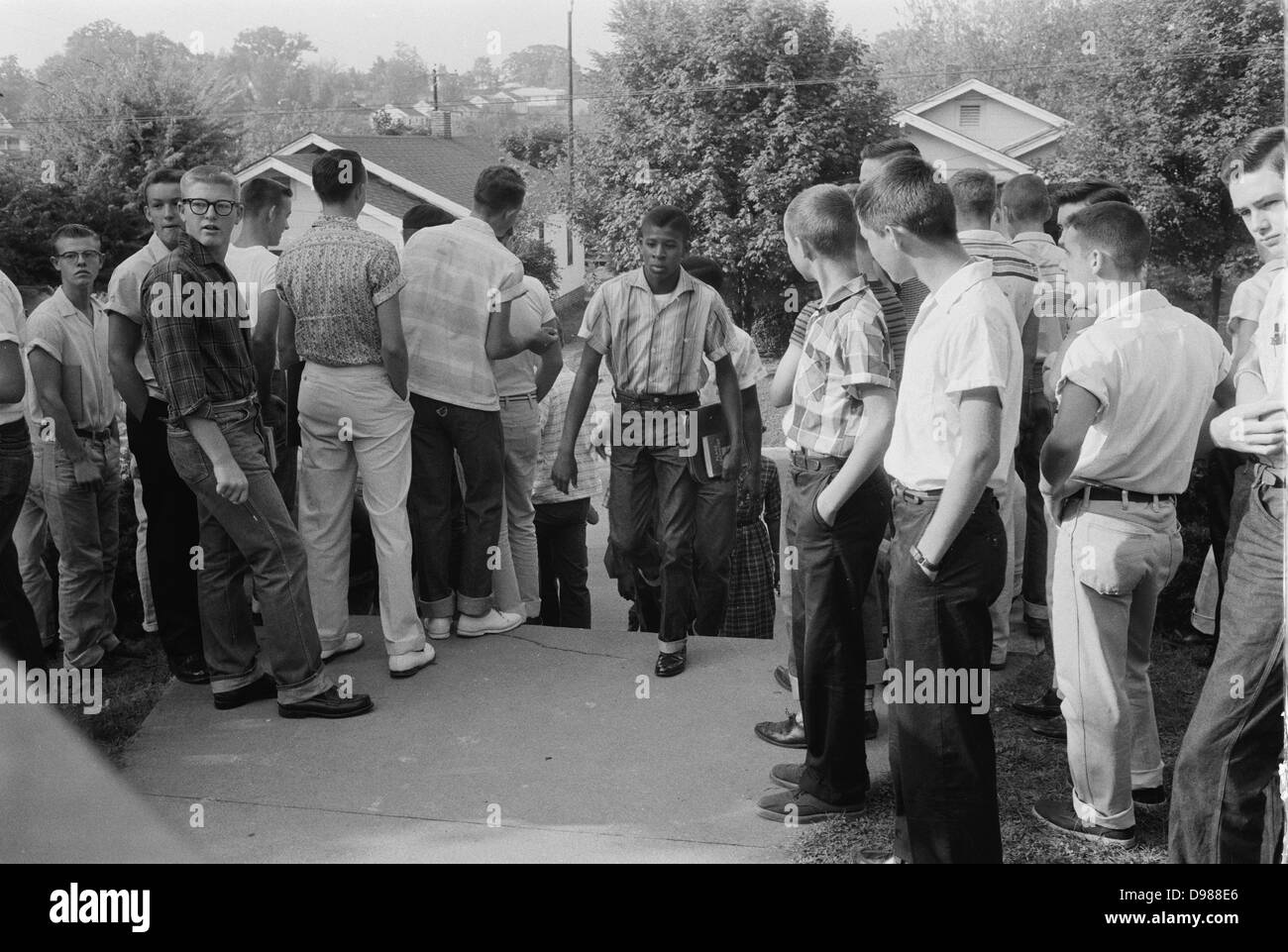 School integration conflicts, Little Rock, Arkansas. Photograph shows an African American boy walking through a crowd of white boys during a period of violence related to school integration. 1957. Thomas J O'Halloran, photographer. Stock Photo
