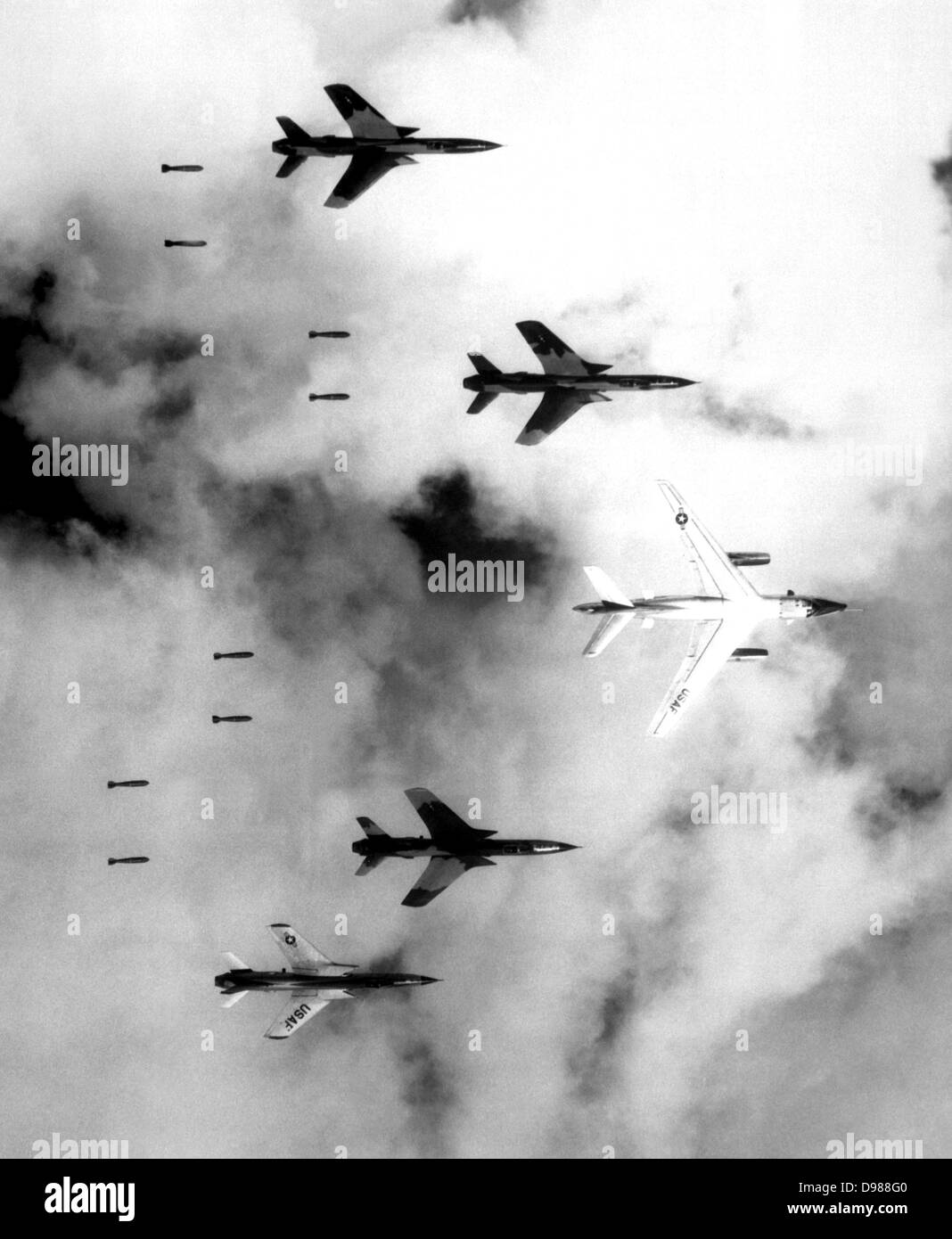 Flying under radar control with a B-66 Destroyer, Air Force F-105 Thunderchief pilots bomb a military target through low clouds over the southern panhandle of North Vietnam, 14 June 1966. Stock Photo