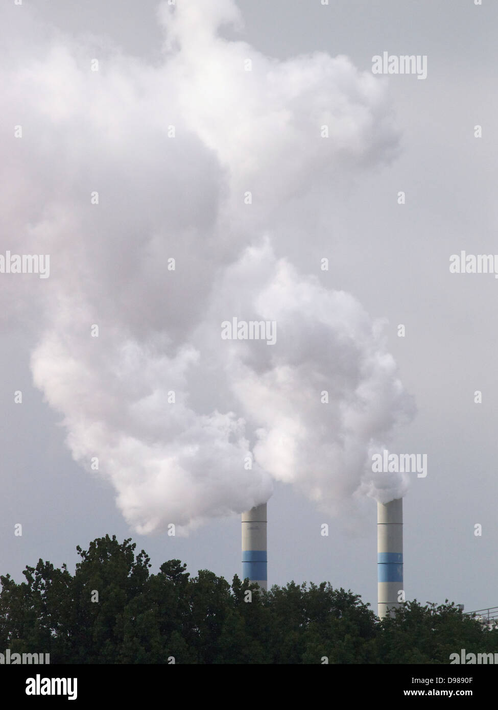 Two tall smoke stacks producing a very large white cloud in the port of Rotterdam, the Netherlands Stock Photo