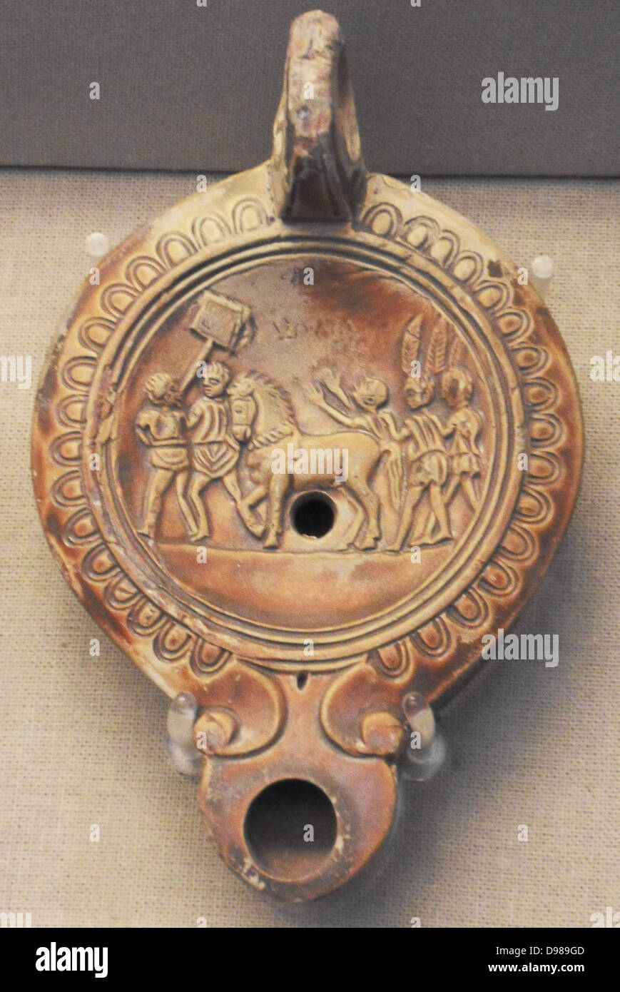 Terracotta lamp with the victorious principal racehorse of a chariot team surrounded by jubilant supporters Stock Photo