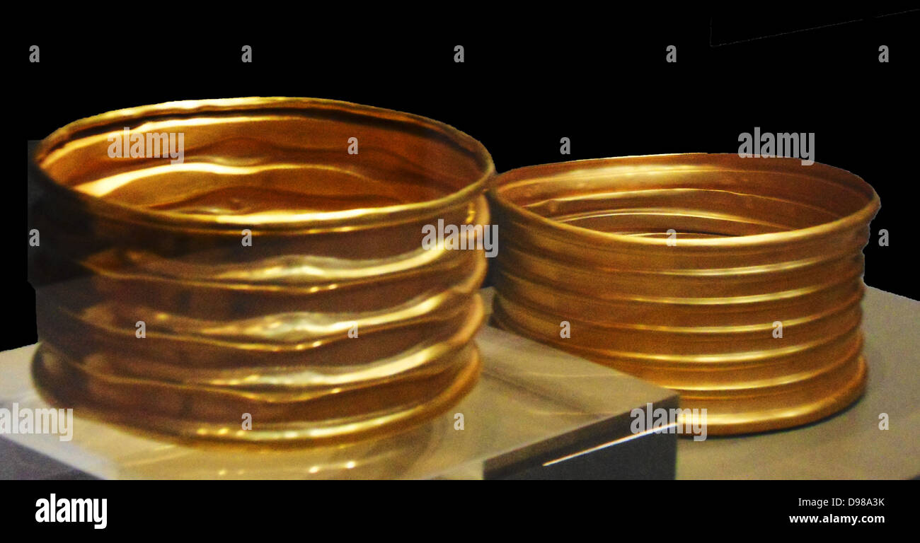 Gold armlets which were found during the excavation of a small pit on the edge of a burial mound.  They lay next to a long copper dagger in its sheath and two fragmentary pottery vessels placed on top. Stock Photo