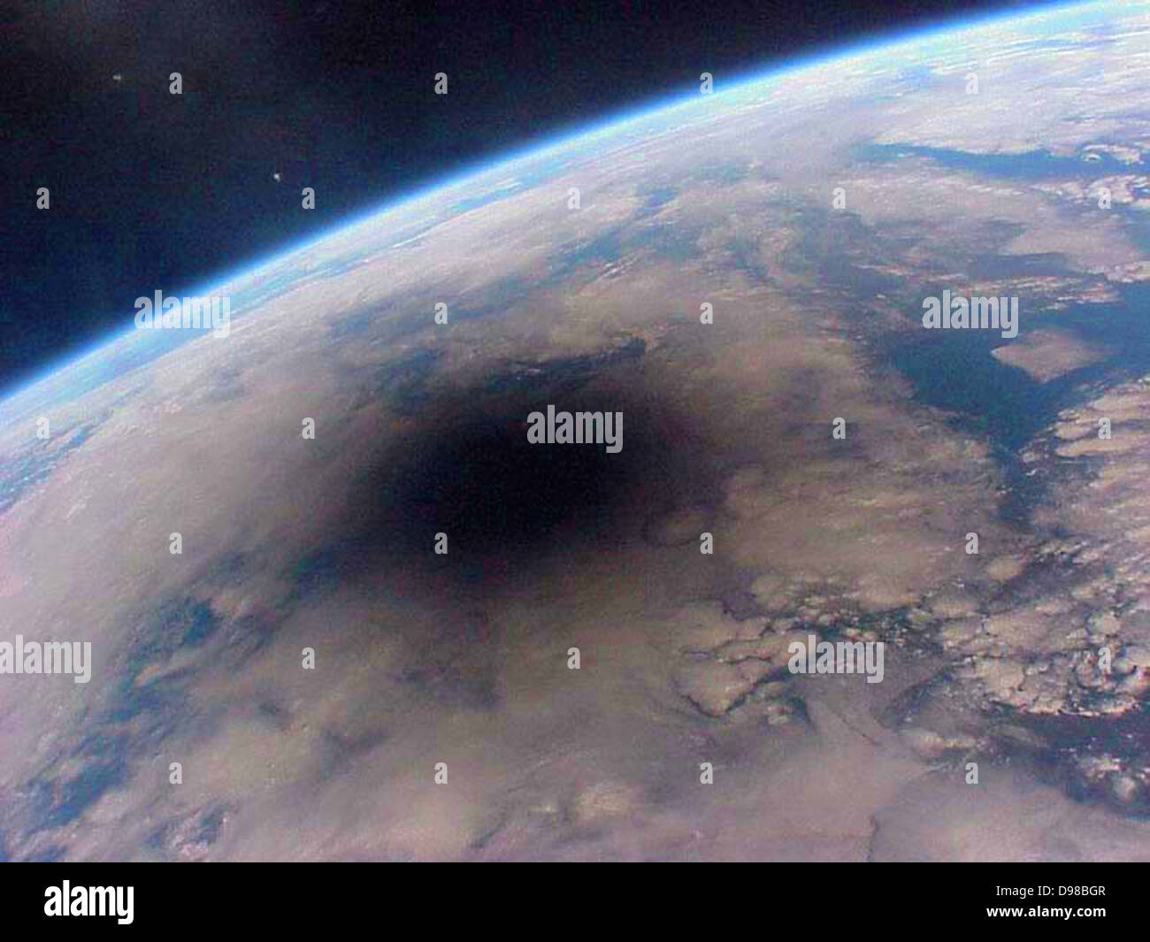 Here is what the Earth looks like during a solar eclipse. The shadow of the Moon can be seen darkening part of Earth. This Stock Photo