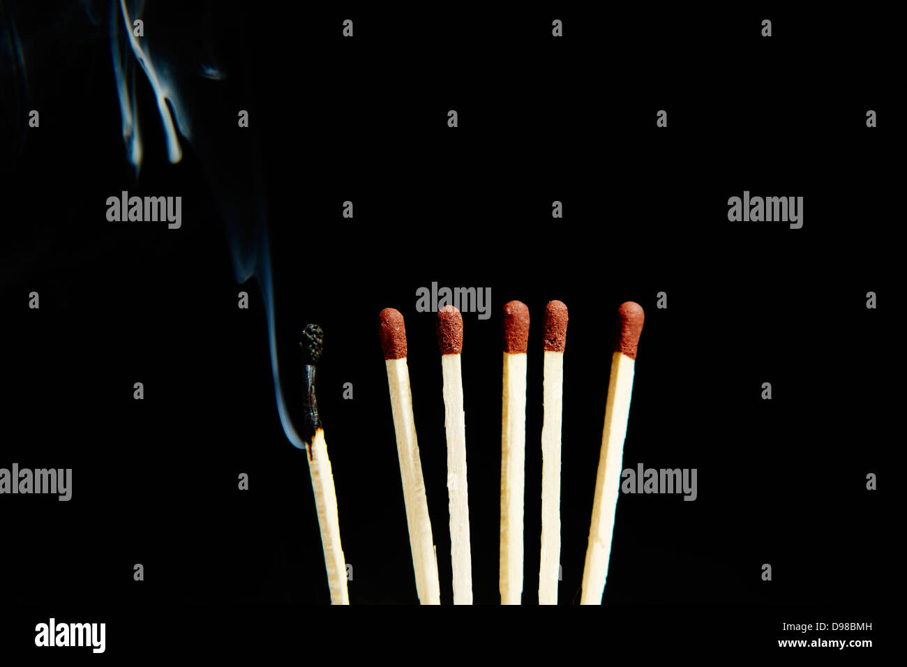 Burnt matchstick beside matches Stock Photo