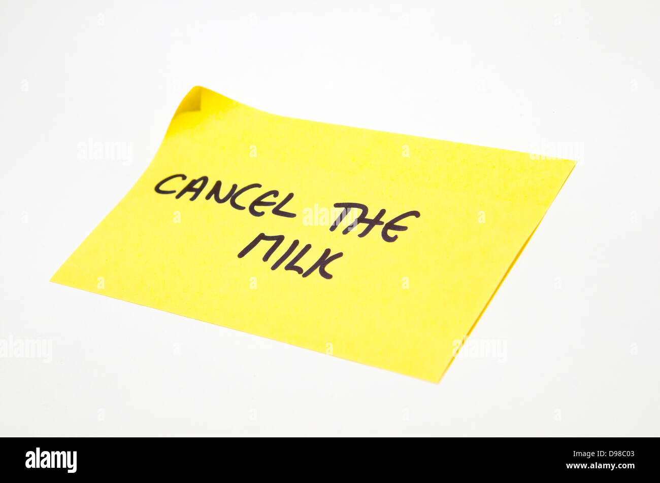 'Cancel the milk' written on a yellow post it note Stock Photo