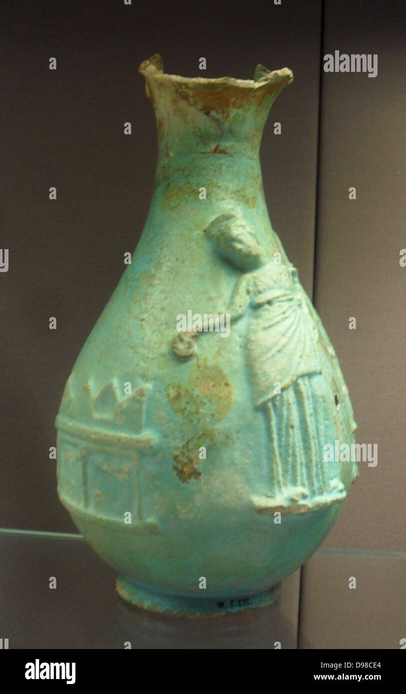 Faience oinochoai (jugs).  This type of jug was used in the cult of the Hellenistic queens of Egypt, who received divine honours in their own lifetime.  On each, the queen is shown pouring a libation at an altar, while behind her is a sacred pillar.  Ptolemy IV was the only male ruler to appear on the jugs, as seen in a fragment displayed alongside. Stock Photo