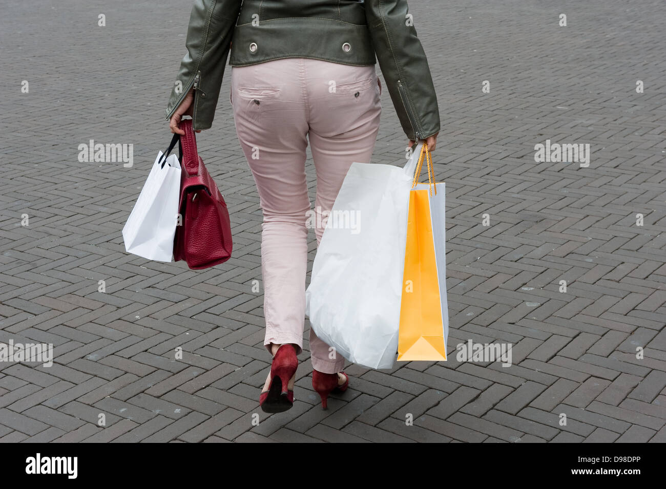 A woman walking on the street with shopping bags Stock Photo