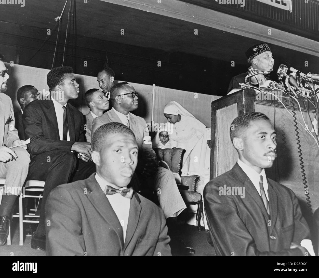 Elijah Muhammad (1897-1975, born Elijah Poole). Converted to Islam in 1931, from 1934 until his death be was leader of the Nation of Islam. Here in 1964 addressing followers including Cassius Clay (Muhammad Ali). Stock Photo
