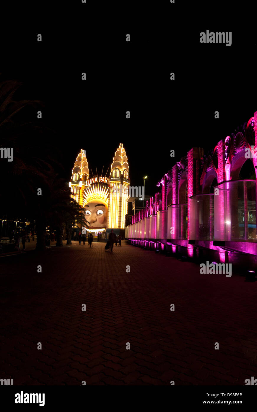 The face of Luna Park at night, with the lights outside Sydney Olympic Swimming Pool on the right. Stock Photo
