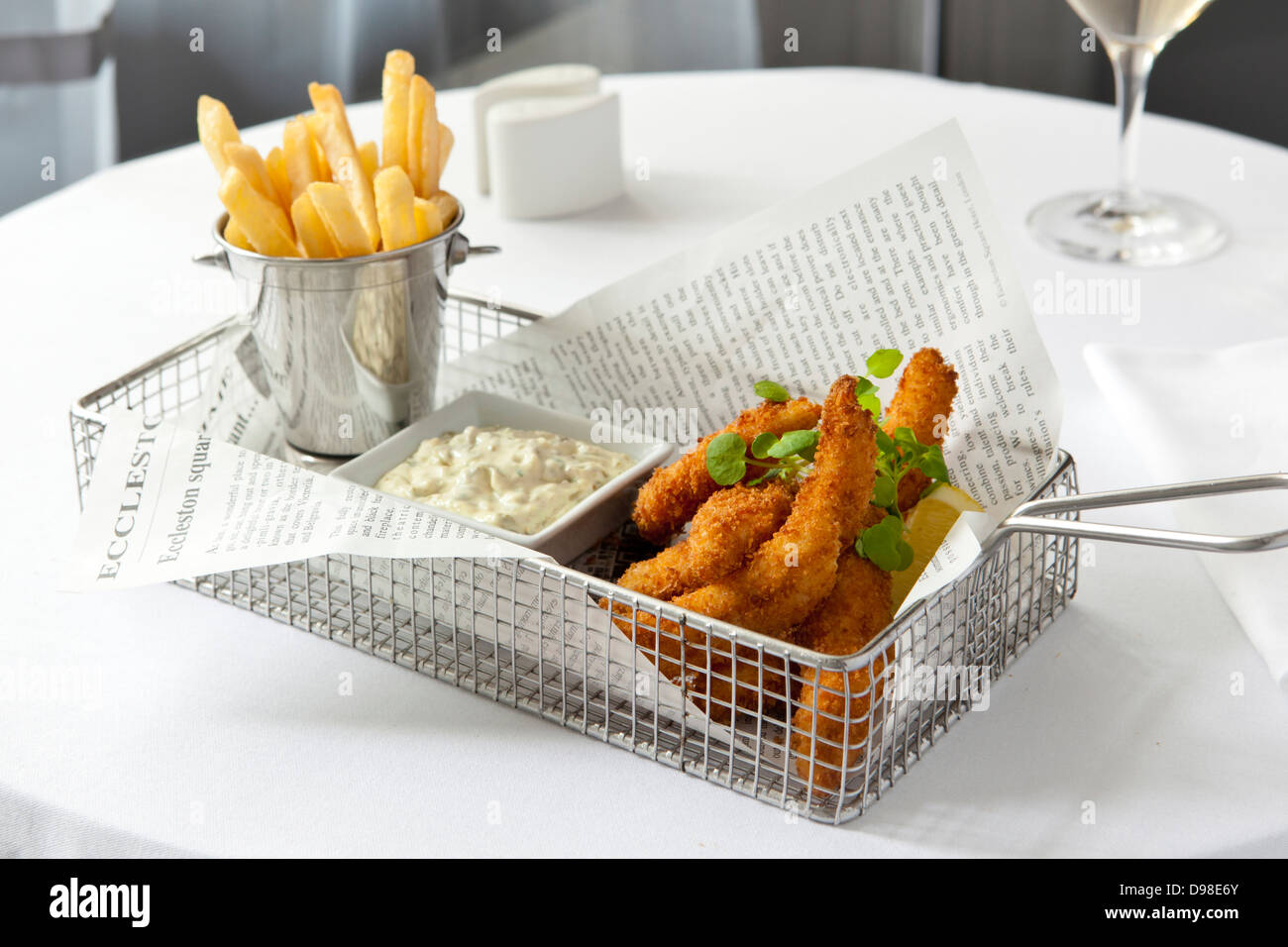 Fish goujons with french fries and tartar sauce in a wire basket Stock Photo