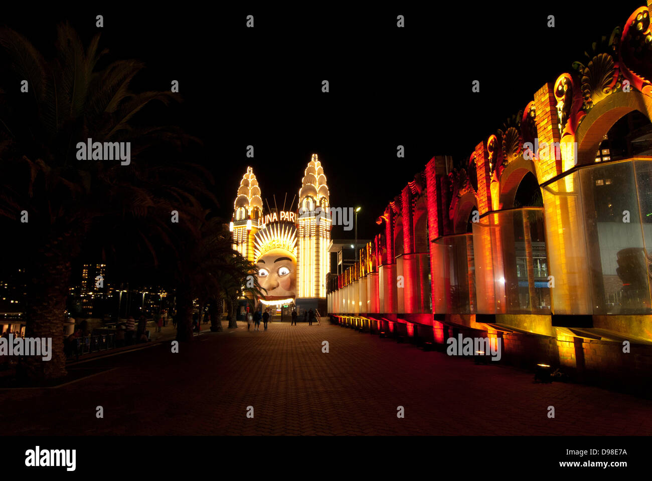 The face of Luna Park at night, with the lights outside Sydney Olympic Swimming Pool on the right. Stock Photo