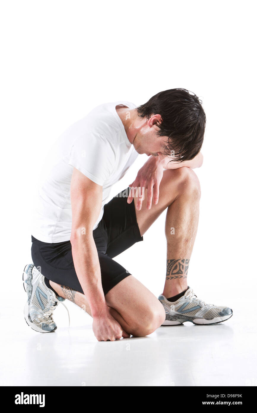 young-man-kneeling-on-white-background-D98F9K.jpg