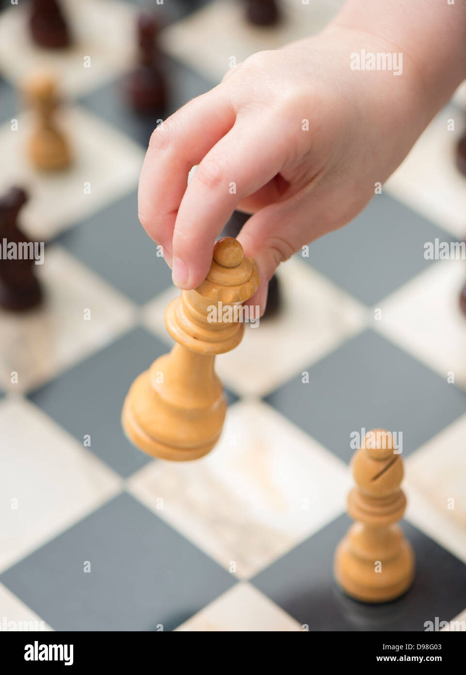 Chess player hand making move with white queen to checkmate
