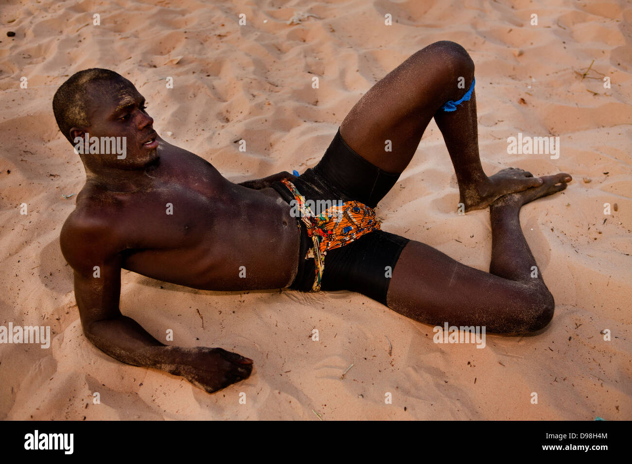 Young wrestlers training on the sand in the village of Dionewar situated on a desert island in the mouth of the river Saloum. No visit to Senegal is complete without experiencing the sights and sounds of a traditional Sereer wrestling match, known in Sereer as Njoom. Moreover, there is no better place to witness such a spectacle than with its creators. Although today traditional wrestling in Senegal is a national phenomenon, it is rooted in Seereer tradition. Stock Photo