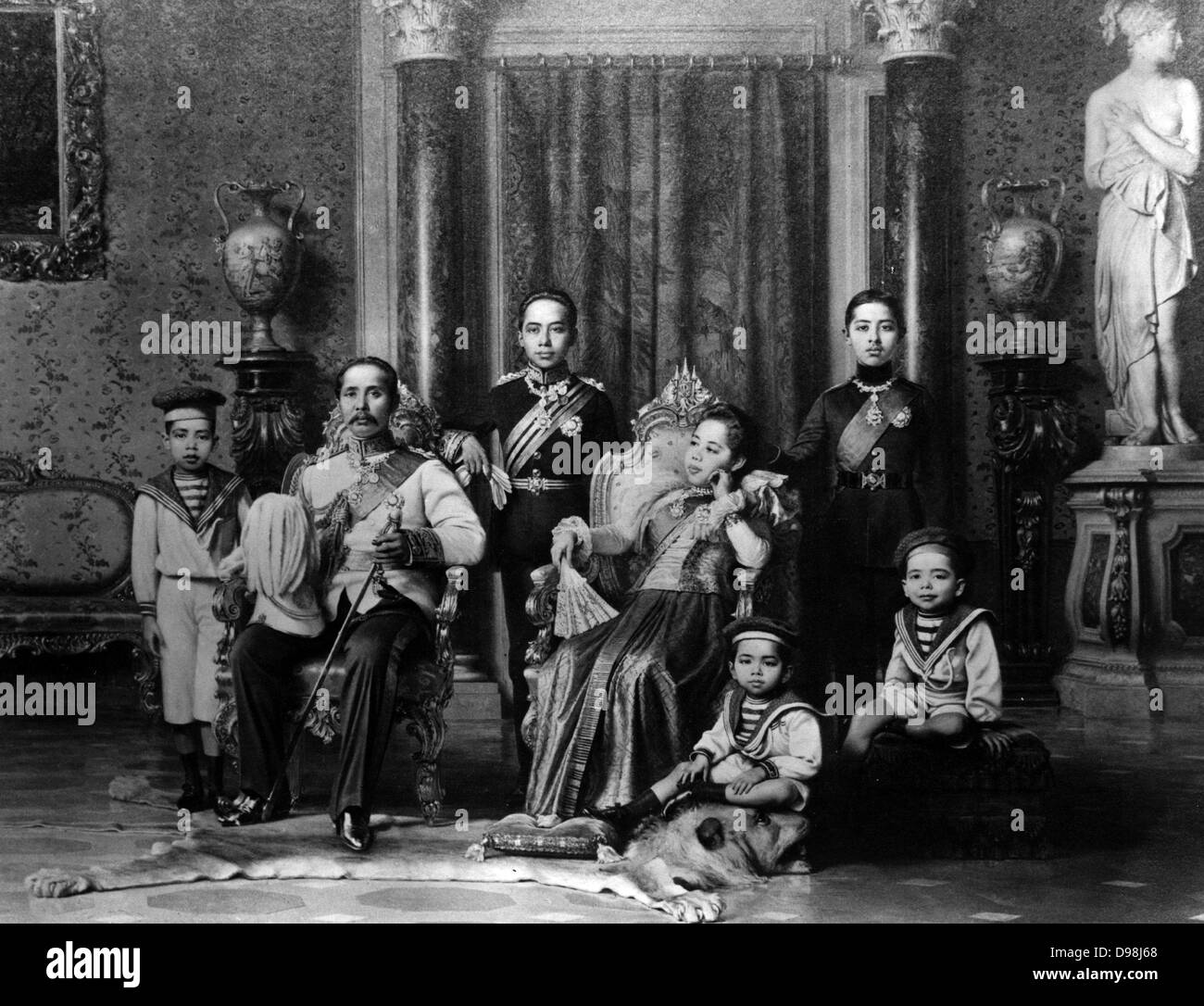 King Chulalongkorn the Great (Rama V) of Siam, with his family. In this photo, Crown Prince Vajirunhis leans on his father's chair, while the future King Rama VI, Prince Vajiravudh, stands behind the queen's chair. It's not entirely clear which of Chulalongkorn's four queens is pictured here, but she most resembles Queen Saovabha Bongsri, the mother of Vajiravudh. Crown Prince Vajirunhis died unexpectedly at the age of 16 in 1894, so Chulalongkorn was succeeded by Vajiravudh instead in 1910. Stock Photo