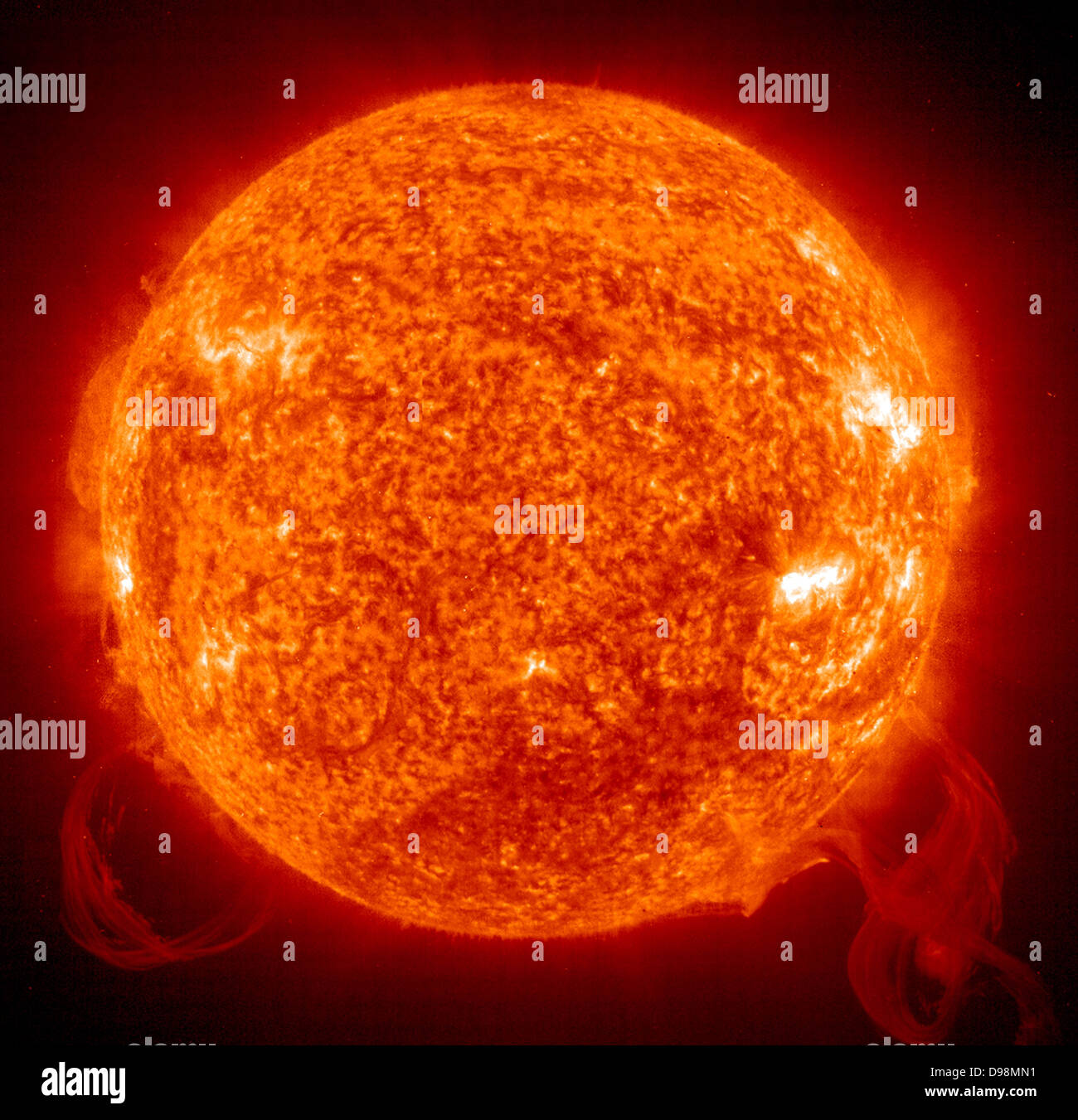 Two large solar prominences in extreme ultraviolet light (ionized helium at 304) roughly the same size but quite different in Stock Photo