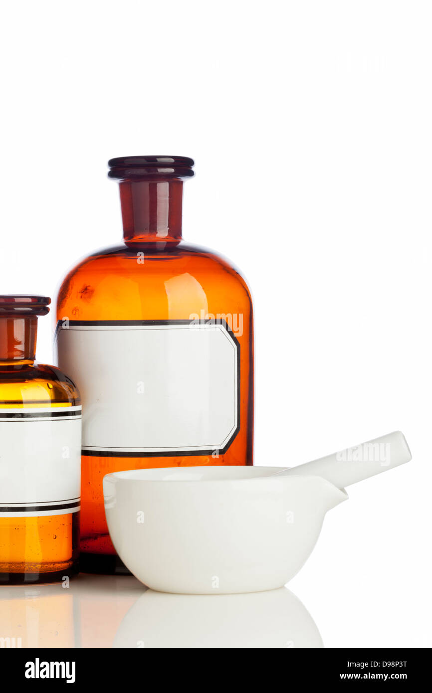 Old pharmacy bottles with blank labels and mortar on white background Stock Photo