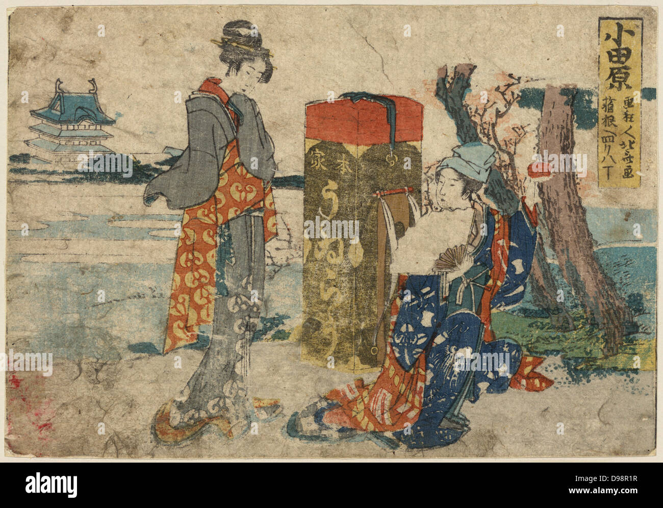 Two travellers, one standing one kneeling holding a fan, a large trunk between them. Print 1804. Katsushika Hokusai (1760-1849) Japanese Ukiyo-e artist. Stock Photo