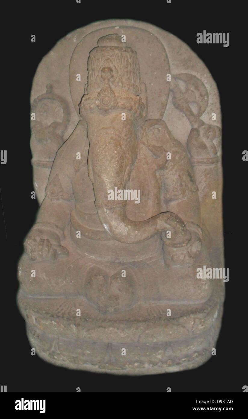 The Hindu god Ganesha (the elephant god). In his right hand the god of wisdom holds aset of prayer beads and his broken tusk. The left hand holds an axe and a bowl of sweetmeats. Eastern Javanese andesite stone sculpture. Indonesia. 13th century Stock Photo