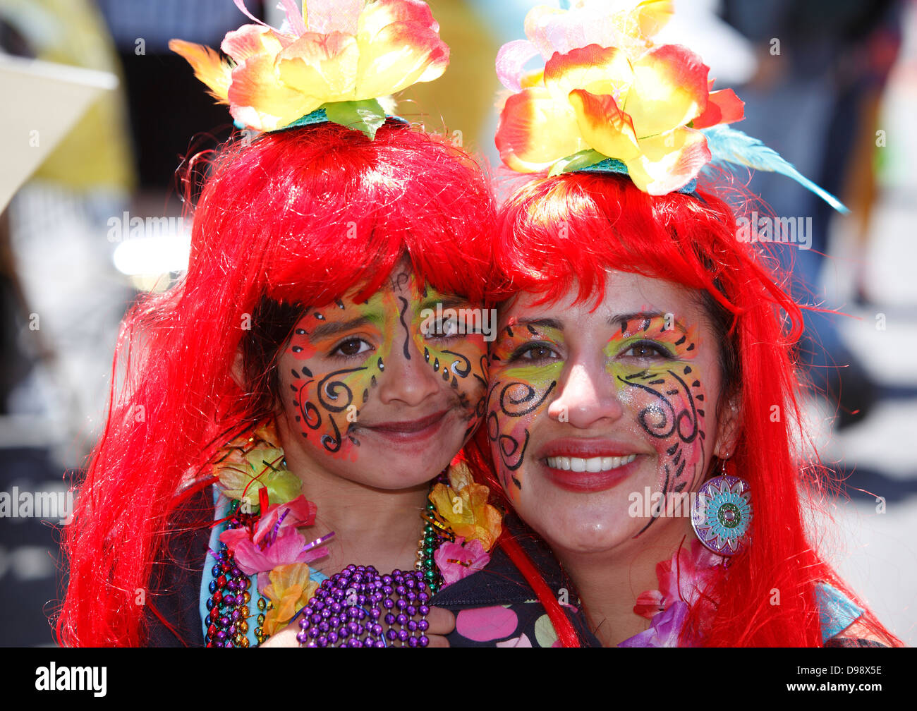 Young girl with mother at Carnaval parade in Mission District, San Francisco, California, USA Stock Photo