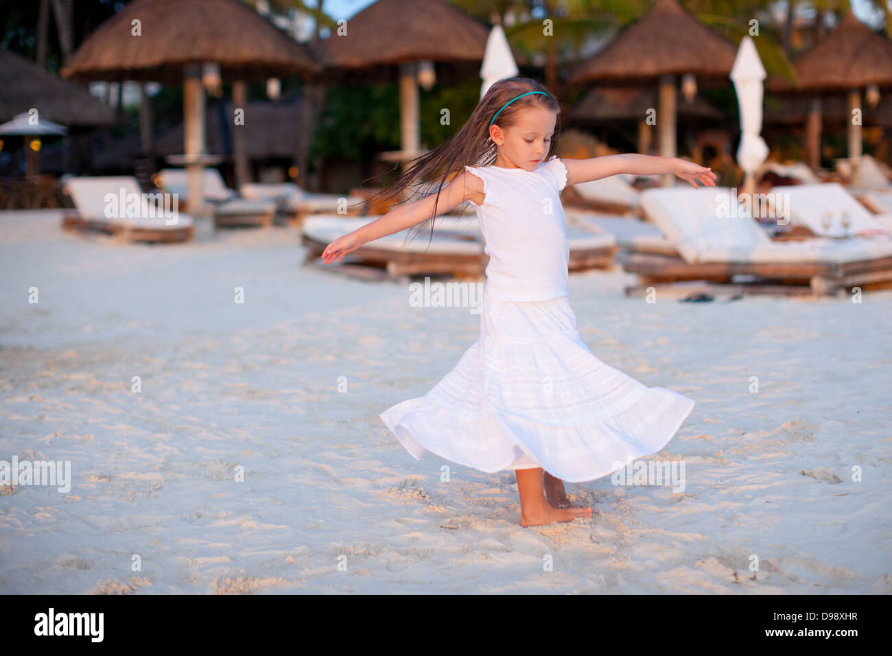 Adorable little girl in beautiful clothes dancing at tropical beach Stock Photo Alamy