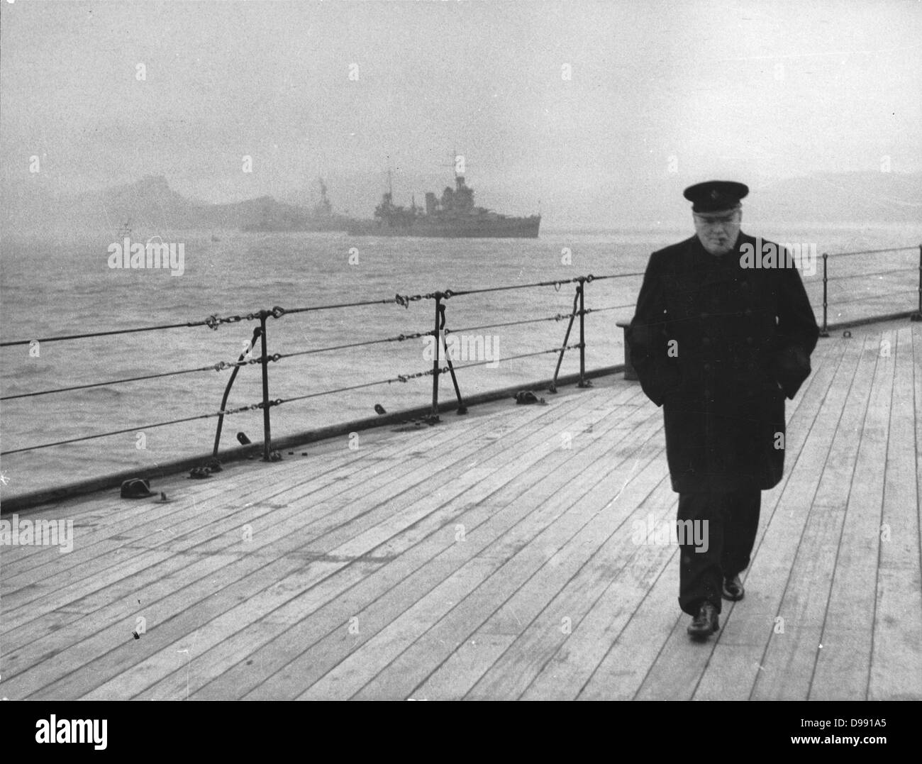 World War II: Winston Spencer Churchill (1874-1965) British statesman, in overcoat and hat and smoking a cigar, walking alone on the deck of HMS 'Prince of Wales' during the Atlantic Conference, 1941. Stock Photo