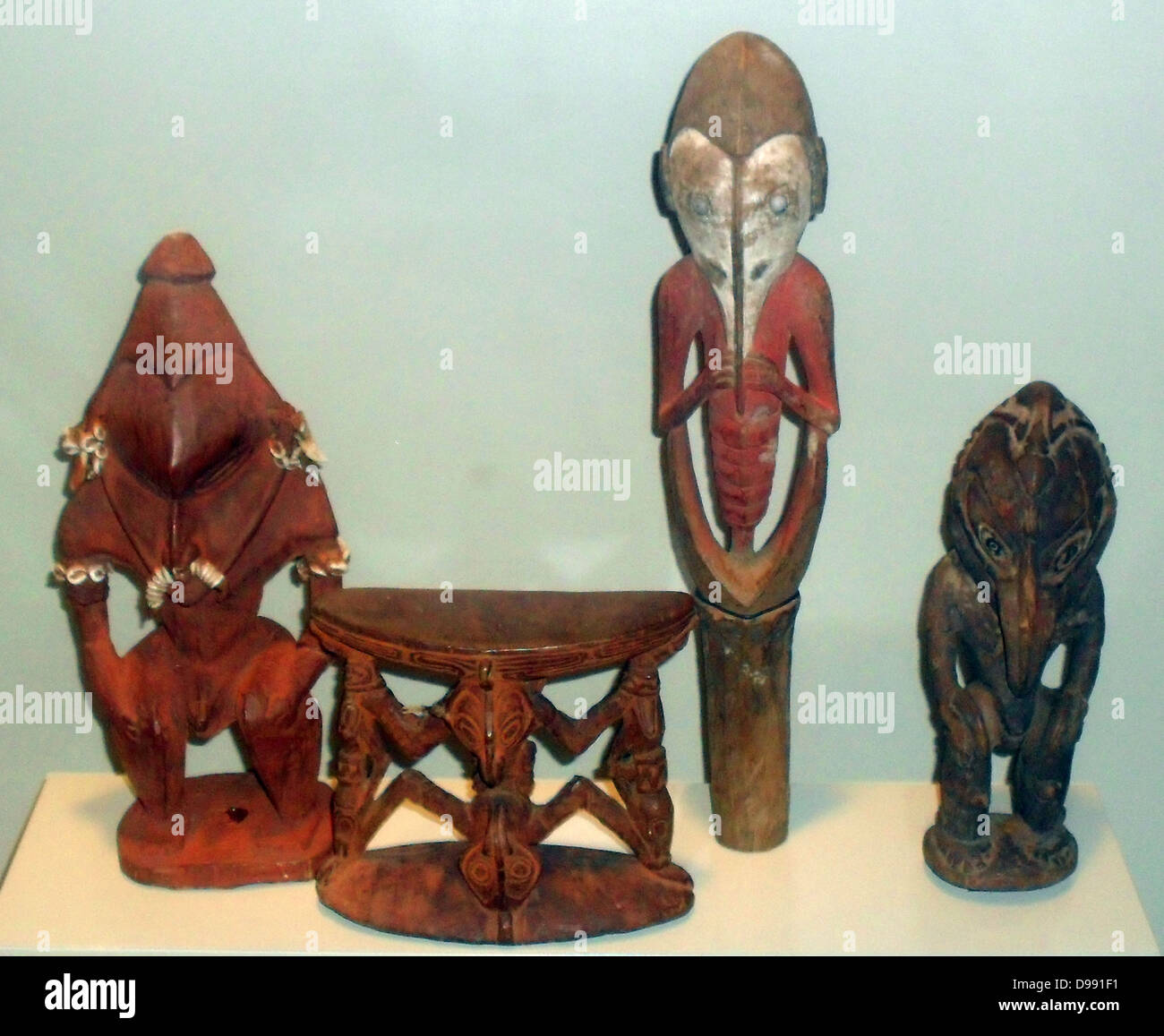 Neck rest and protective figures in wood. Sepik region of Papua New Guinea. Early 20th century Stock Photo