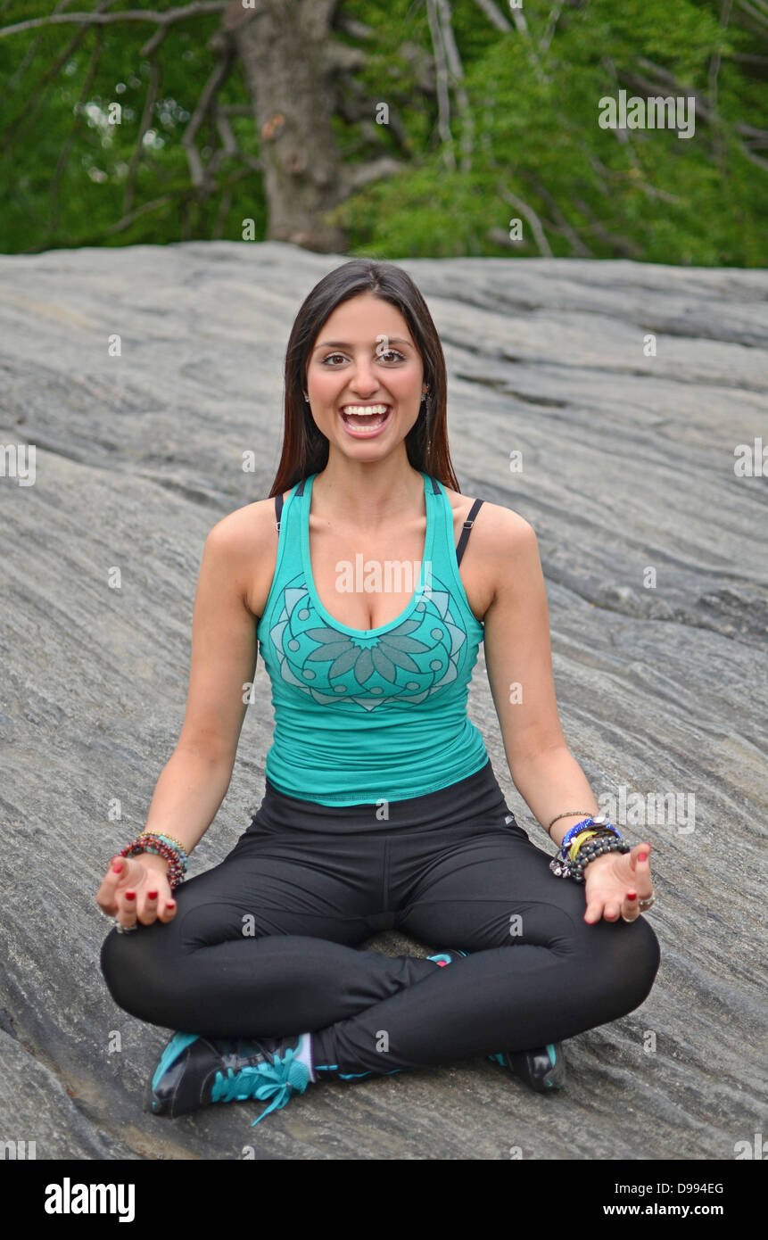 Attractive young mixed race woman practicing yoga in Central Park, New