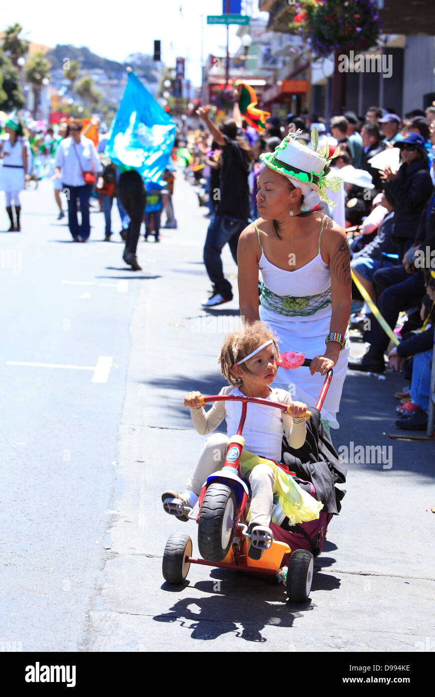 Mother and child in a play stroller during Carnaval parade in Mission District, San Francisco, California, USA Stock Photo