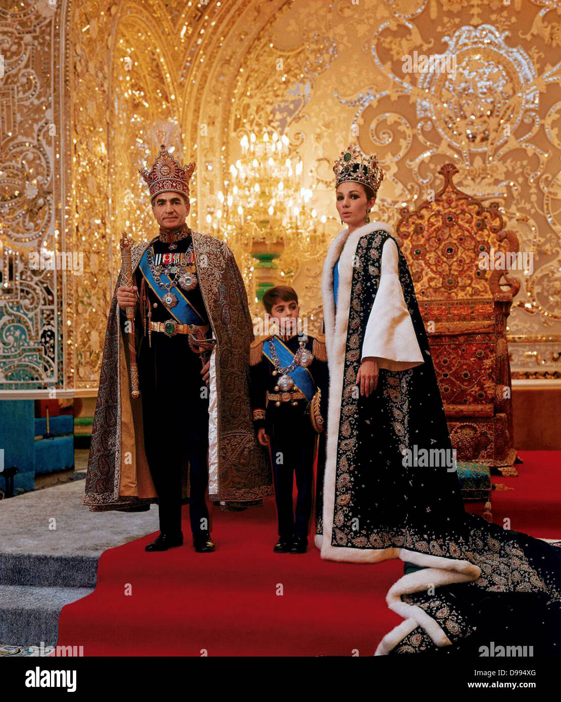 Mohammed Reza Shah Pahlavi (1919-1980) Shah of Iran 1941-1979, with his third wife Farah Diba and their son Reza in ceremonial dress in front of throne. Stock Photo