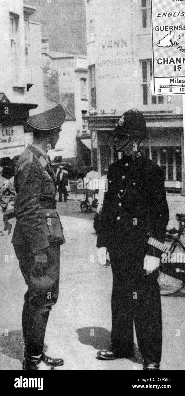 German army officer talking to a policeman in British uniform, St Helier, Jersey. The Channel Islands, part of Great Britain, were under German military occupation from 30 June 1940 to 9 May 1945. Stock Photo