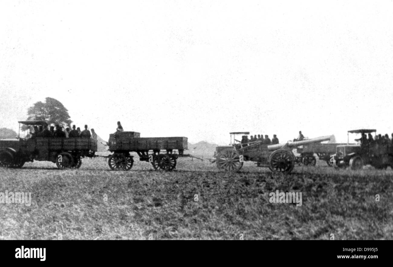 French military motorised vehicles carrying gun crews and a hauling field artillery, c1914. Stock Photo