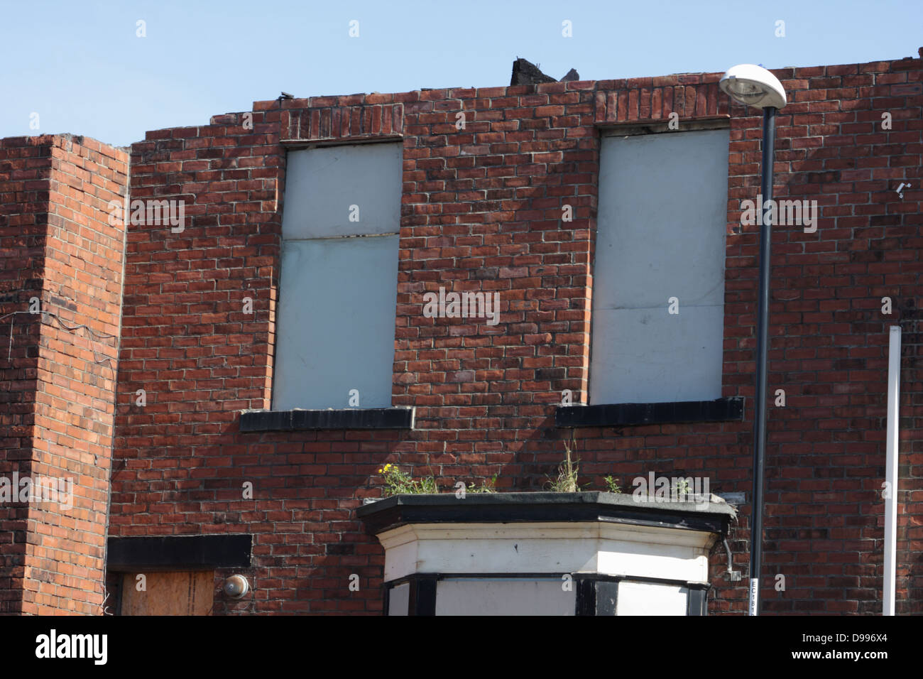 Derelict House, Securely boarded up. Roof is missing. Stock Photo
