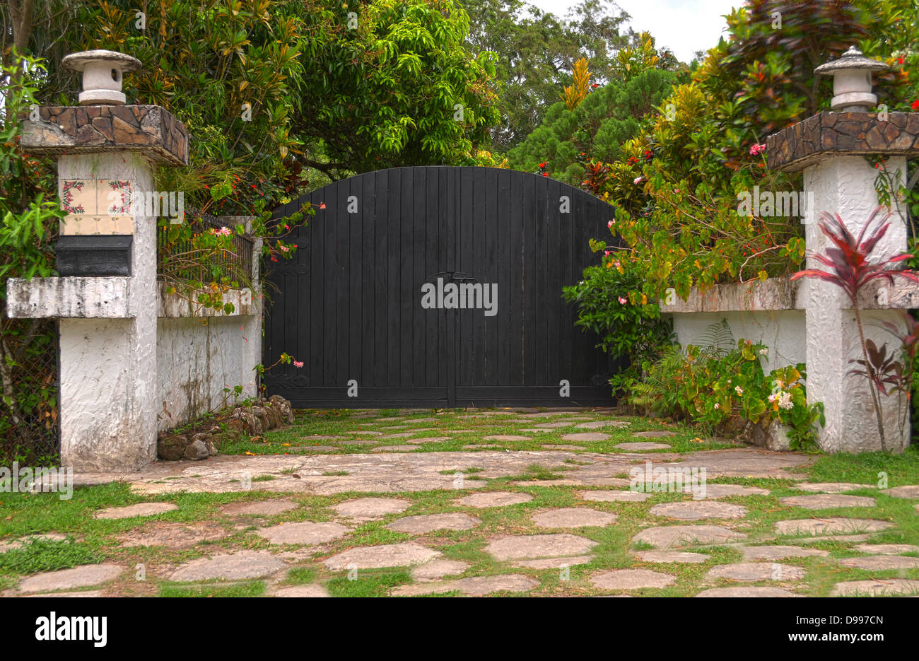 Black wooden front gate with concrete columns Stock Photo Alamy