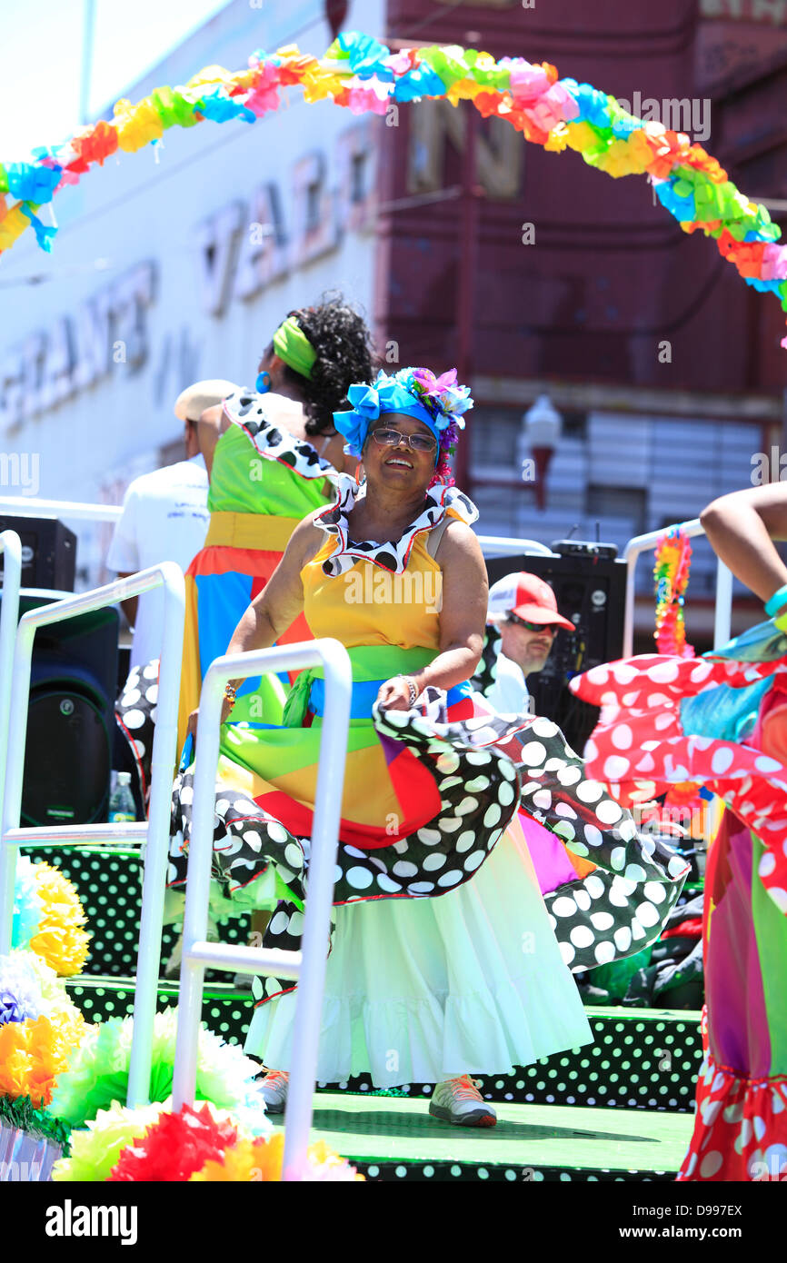 Colorful and spirited dancers on a float during carnaval parade in Mission District, San Francisco, California, USA Stock Photo