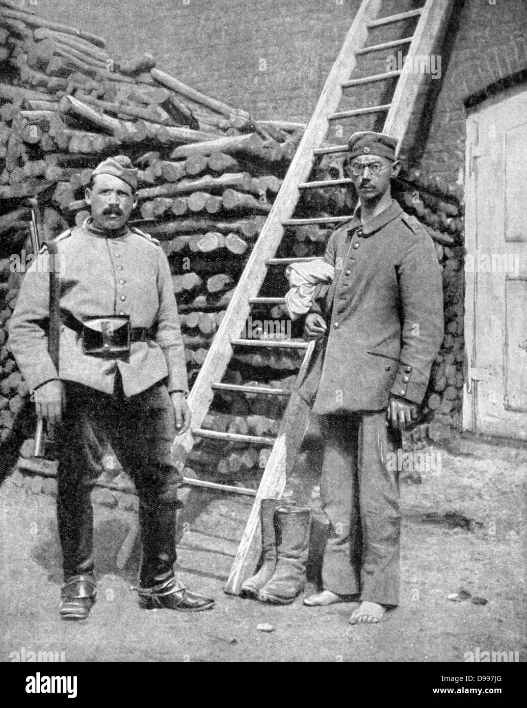 World War I 1914-1918: German prisioner and his French guard. Weedy, bootless prisoner with a puzzled expression, prominent ears, wearing spectacles contasted with smart, strong and confident guard. ' Le Pays de France',  1915. Stock Photo