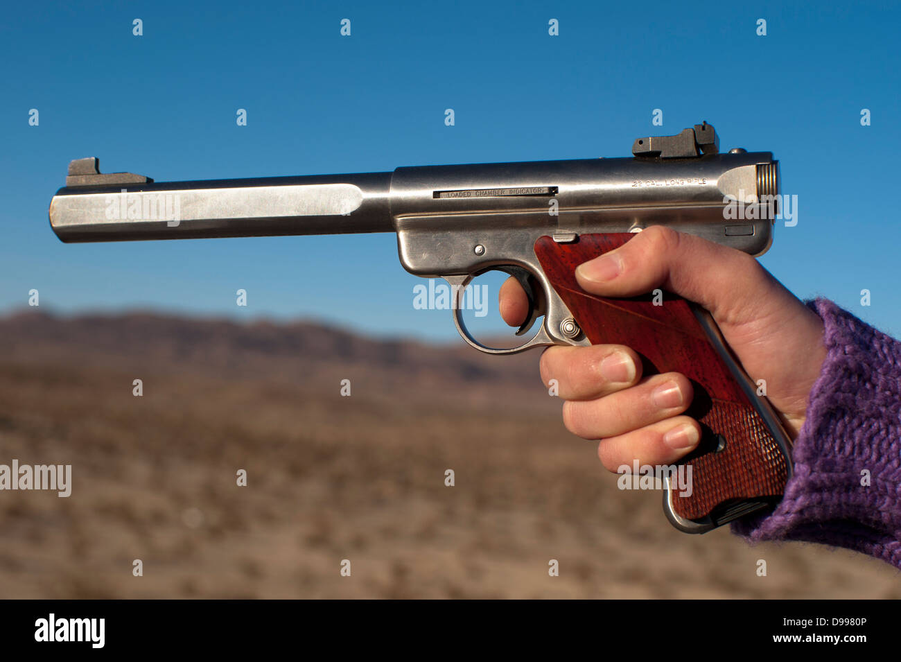 close up of womans hand shooting firearm Stock Photo