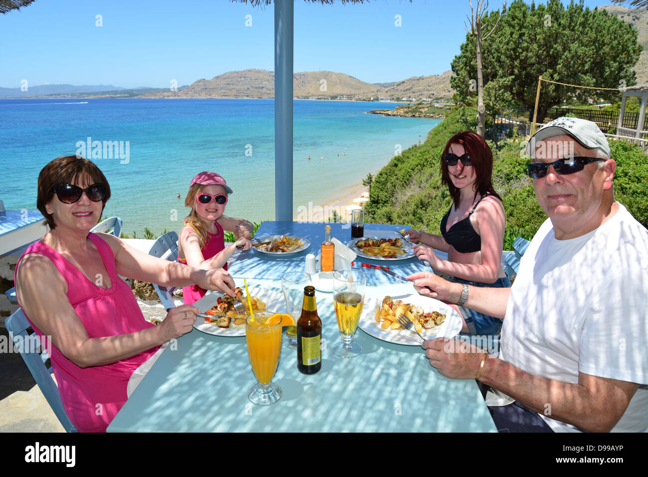 Family eating in 'Philosphia' beach taverna, Pefkos, Rhodes (Rodos), The Dodecanese, South Aegean Region, Greece Stock Photo