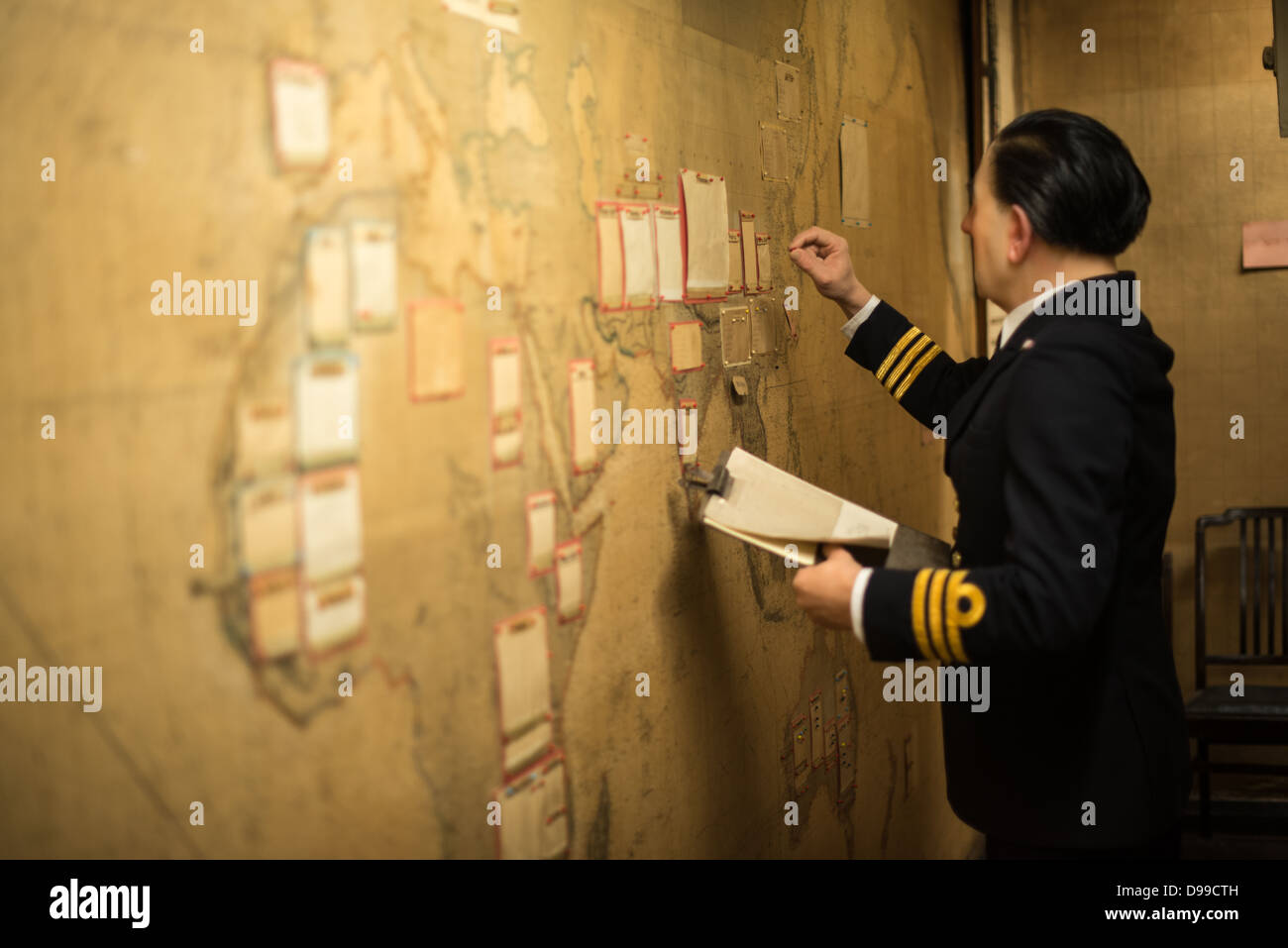 LONDON, UK - A manequin of a military officer updating one of the large wall maps in the Map Room at the Churchill War Rooms in London. The museum, one of five branches of the Imerial War Museums, preserves the World War II underground command bunker used by British Prime Minister Winston Churchill. Its cramped quarters were constructed from a converting a storage basement in the Treasury Building in Whitehall, London. Being underground, and under an unusually sturdy building, the Cabinet War Rooms were afforded some protection from the bombs falling above during the Blitz. Stock Photo