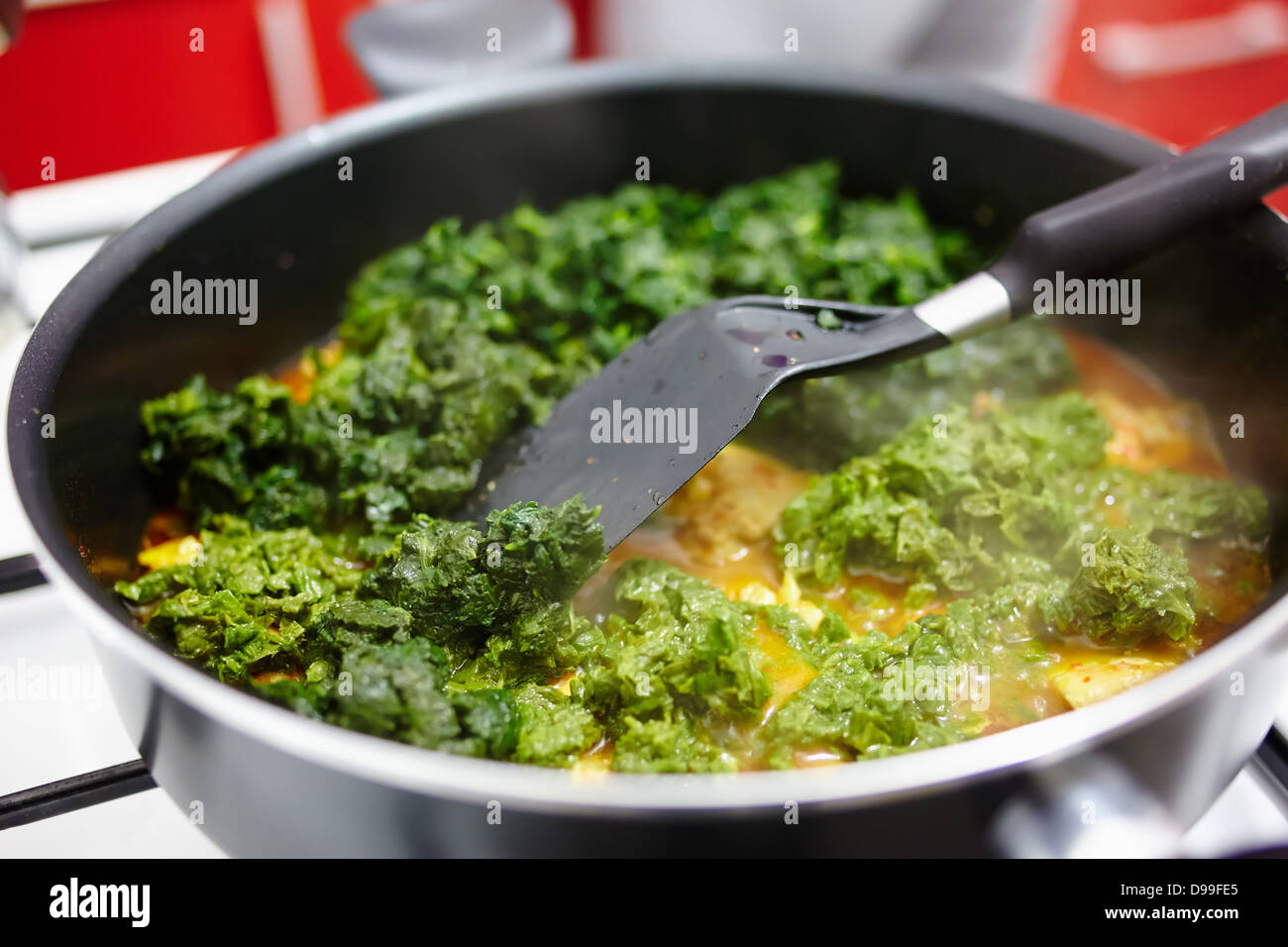 Spinach cooking in a pan on the gas stove Stock Photo Alamy