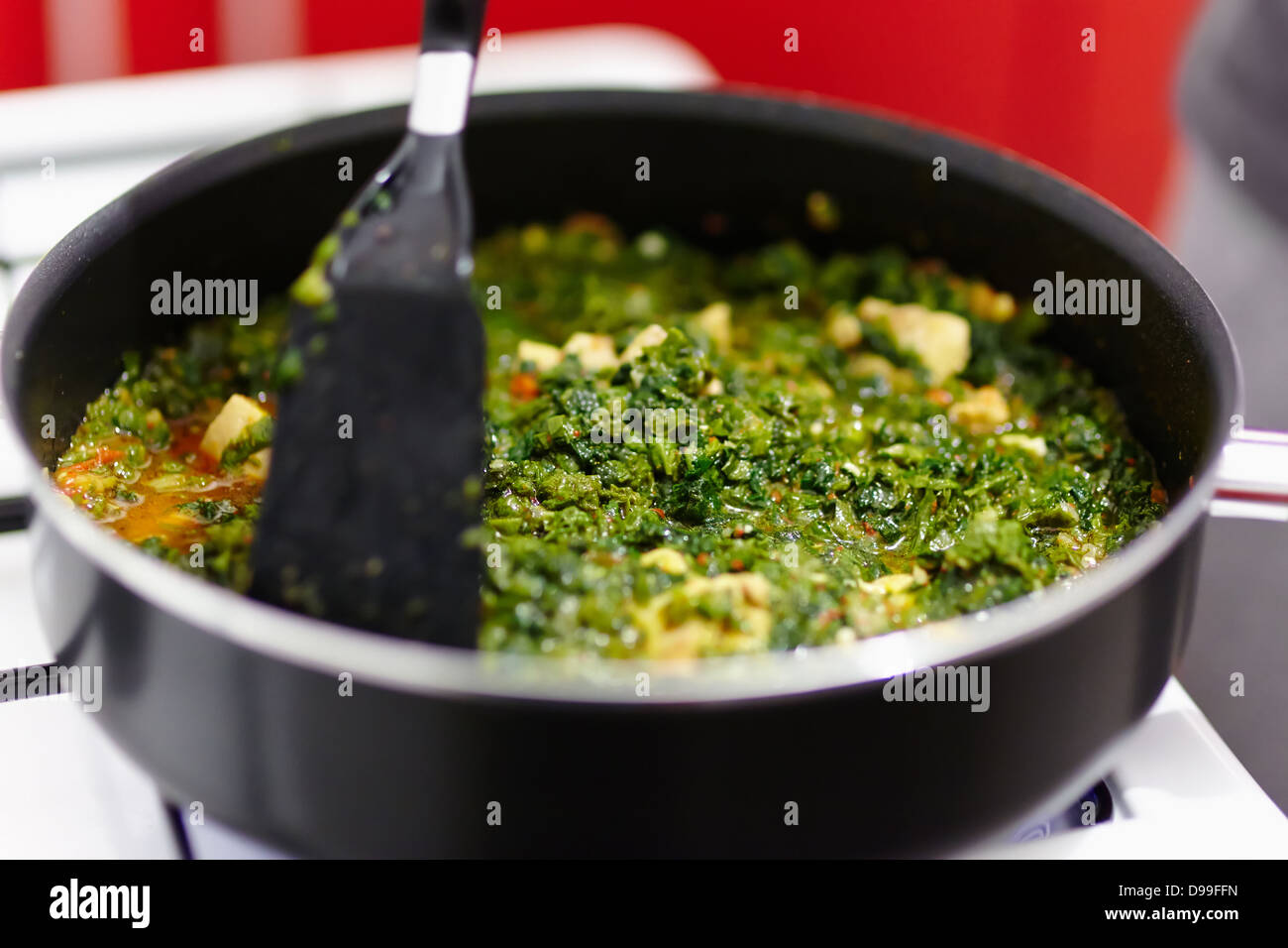 Spinach cooking in a pan on the gas stove Stock Photo - Alamy
