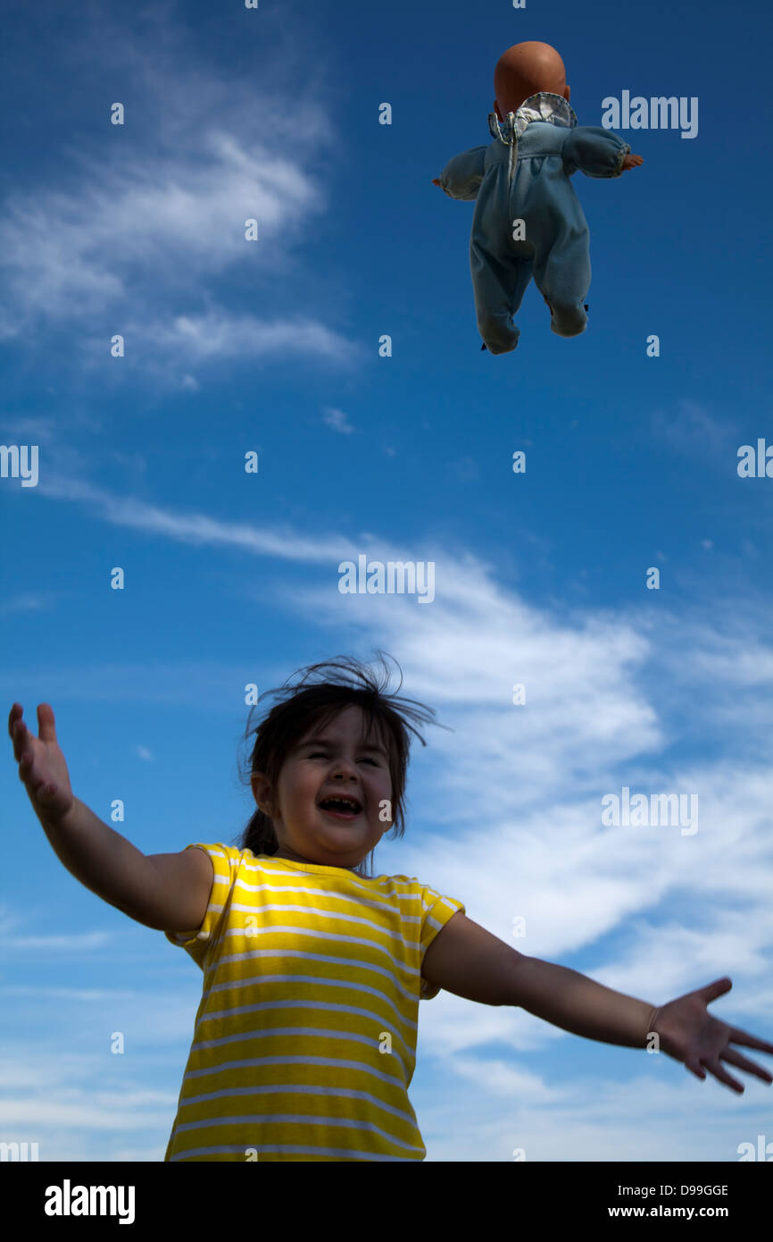 Girl Throwing Baby Doll up in the Air Stock Photo Alamy