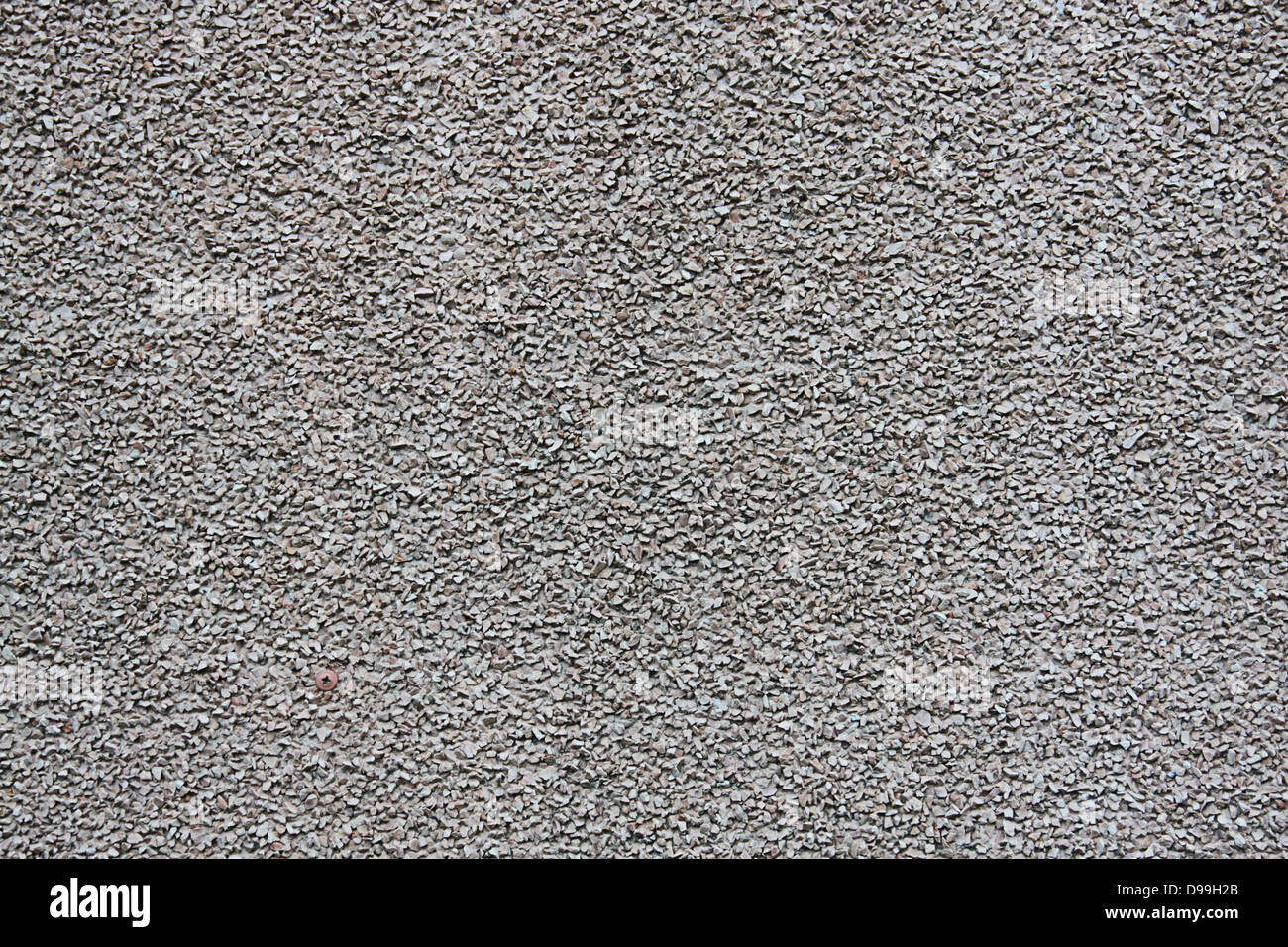 Concrete wall decorated with fine gravel as background Stock Photo