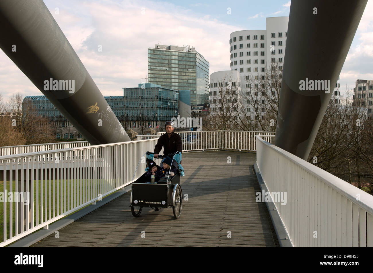 Farther and children cycling through Dusseldorf Germany Stock Photo
