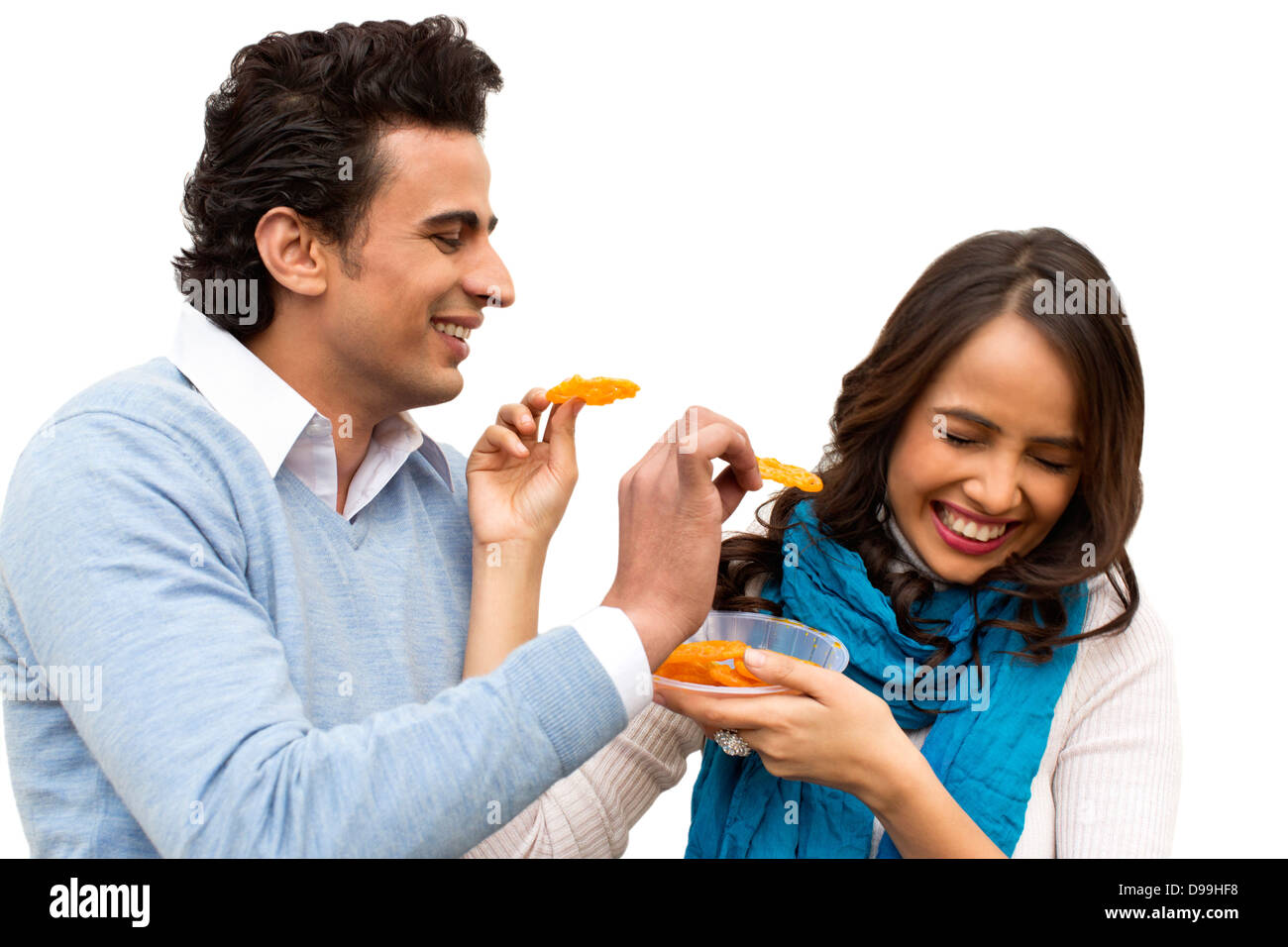 Smiling couple eating jalebis Stock Photo